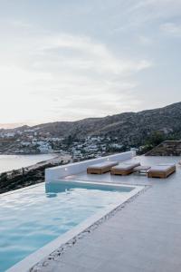 a swimming pool with benches on top of a building at Sea and Sun ll in Ios Chora