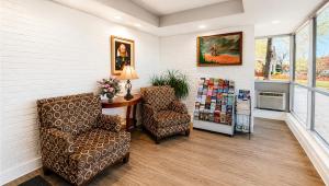 a waiting room with two chairs and a table at Captain John Smith Inn Williamsburg in Williamsburg