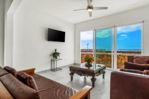 a living room with a couch and a tv at Dog-friendly Home with Partial Ocean View, Heated Pool, Rooftop Terrace in Rosarito