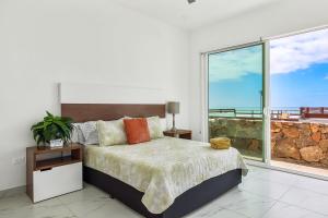 a bedroom with a bed and a large window at Dog-friendly Home with Partial Ocean View, Heated Pool, Rooftop Terrace in Rosarito +39 photos