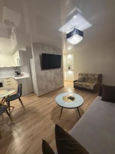 a living room with a couch and a table at Urban Place by Kelvin in Narva