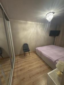 a bedroom with a bed and a chair in it at Urban Place by Kelvin in Narva