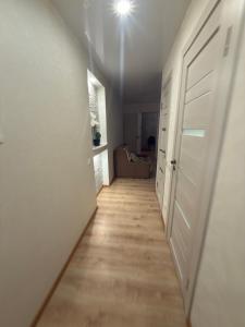 a hallway with a white door and a wooden floor at Urban Place by Kelvin in Narva +1 photo