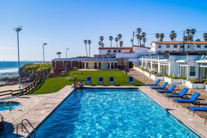 a pool with chairs and the ocean in the background at Dog-friendly Villa with Heated Pool, Hot Tub, Streaming, Partial Ocean Views in Rosarito