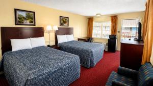 a hotel room with two beds and a couch at Captain John Smith Inn Williamsburg in Williamsburg