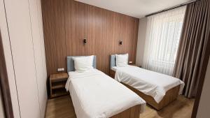 a small room with two beds and a window at Turon plaza hotel in Bukhara +25 photos