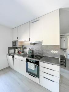 a kitchen with white cabinets and stainless steel appliances at Apartmán Proseč-Obořiště in Nová Cerekev