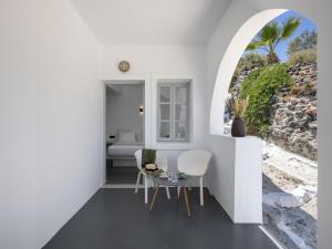 a white room with two chairs and a table at Elios Cave Suites in Oia