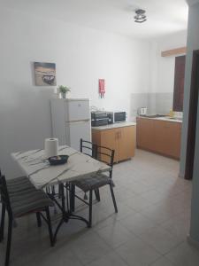 a kitchen with a table and chairs in a room at PHILIPPOS STUDIOS & APT in Lindos