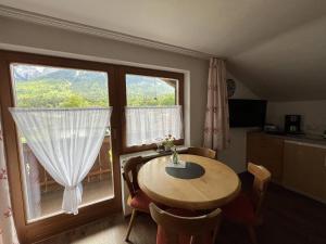 a dining room with a table and a large window at Ferienwohnung 2 Am Krepbach in Grainau