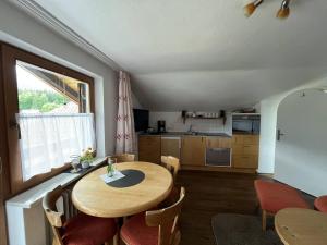 a kitchen and dining room with a wooden table and chairs at Ferienwohnung 2 Am Krepbach in Grainau