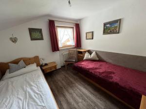 a bedroom with a bed and a desk and a window at Ferienwohnung 2 Am Krepbach in Grainau