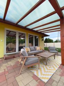 a covered patio with a couch and a table at Marilyn Vendégház in Kehidakustány