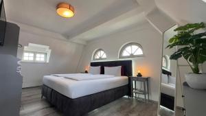 a bedroom with a large white bed with two windows at Alter Kornspeicher in Havelberg