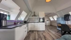 a large kitchen with white cabinets and a table at Alter Kornspeicher in Havelberg