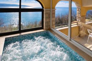 a jacuzzi tub in a house with windows at Villas Verde Dalmatia in Jesenice