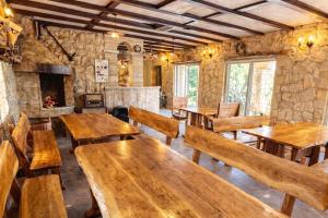 a restaurant with wooden tables and chairs and a fireplace at Villas Verde Dalmatia in Jesenice