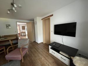 a living room with a flat screen tv on a wall at Ferienwohnung 1 Am Krepbach in Grainau