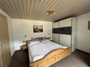a bedroom with a large bed with a wooden ceiling at Ferienwohnung 1 Am Krepbach in Grainau