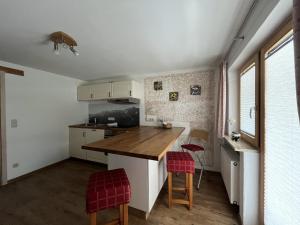 a kitchen with a counter and two stools at Ferienwohnung 1 Am Krepbach in Grainau