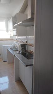 a kitchen with white cabinets and a counter top at Playa a dos pasos in Santa Pola