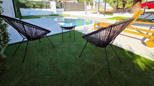 two chairs and a table next to a swimming pool at Dolce Far Niente Greece in Agioi Theodoroi