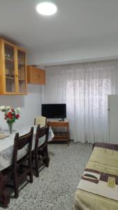 a living room with a table and chairs and a television at Playa a dos pasos in Santa Pola