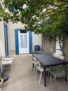 a black table and chairs in a courtyard at Maison familiale en centre bourg in Ahun