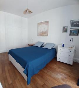 a bedroom with a blue bed and a white dresser at Maison familiale en centre bourg in Ahun