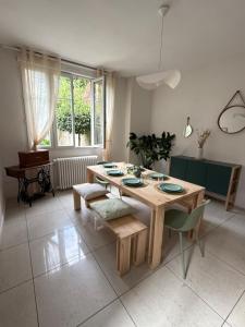 a dining room with a wooden table and chairs at Maison familiale en centre bourg in Ahun +16 photos