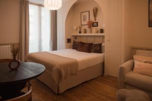a bedroom with a bed and a table and a chair at Sezam Appart-Hotel Rennes in Rennes