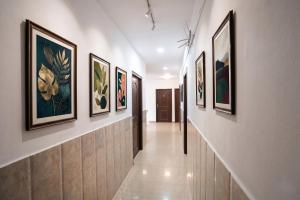 a hallway with framed paintings on the walls at FabHotel The Max in Lucknow