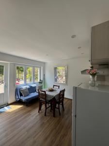 a kitchen and living room with a table and a couch at Villa Rosmarino sea view in Capraia
