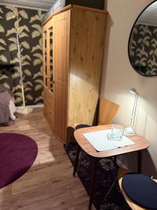ein Zimmer mit einem Tisch und einem Holzschrank in der Unterkunft Stuga Millby in Orsa