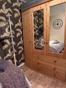 ein Schlafzimmer mit einem Holzschrank, in dem ein Bett steht in der Unterkunft Stuga Millby in Orsa