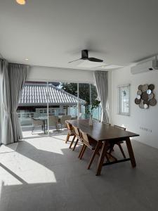 a living room with a wooden table and chairs at Villa Tara - Sea view 5Br Rawai in Ban Saiyuan (1)