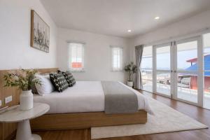 a bedroom with a bed with a table and a balcony at Villa Tara - Sea view 5Br Rawai in Ban Saiyuan (1) +43 photos
