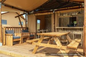 a wooden table and benches on a patio at Camping Loodsmansduin in Den Hoorn