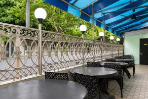 a restaurant with tables and chairs and a fence at Hotel Platinum in Mumbai