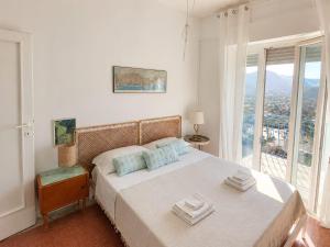 a white bedroom with a bed with a window at CasaAzul in Sperlonga