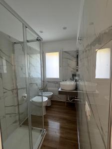 a bathroom with two sinks and a glass shower at Villa Rosmarino sea view in Capraia