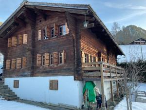 a log cabin in the snow with a porch at Le vieux chalet in La Forclaz