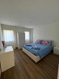 a bedroom with a bed with a blue comforter at Villa Rosmarino sea view in Capraia
