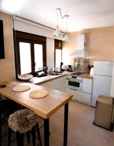 a kitchen with a wooden table and white appliances at Casa Santiago in Panticosa