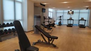 a gym with several treadmills and exercise bikes at Ocean View Escape at The Mactan Newtown in Punta Engaño