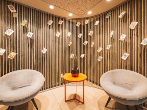 two chairs and a table with money on a wall at ibis Juazeiro do Norte in Juazeiro do Norte