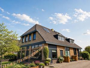 a brick house with a gambrel roof at Groupaccommodation with 10 bedrooms in Scherpenzeel