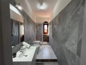 a bathroom with a white sink and a toilet at Casa Relax in Gaggi +10 photos