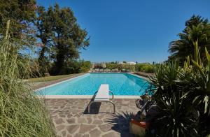 uma piscina com um banco em frente em Podere il Giurato em Fauglia
