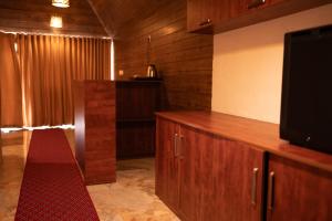 a living room with a television and a red carpet at West Bay Palm Tree Beach Resort in Varkala